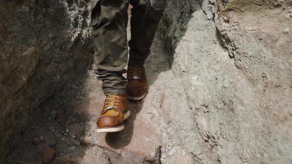 slow-motion of legs of young hiker walking on the rock path