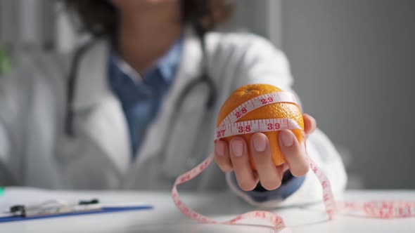 Doctor Nutritionist Holds An Orange In His Hand. Nutritionist Holds Fruit Citrus Orange Color Orange