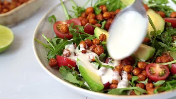 Roasted Chickpea Salad with Avocado and Tomatoes in White Bowl. Healthy Vegan Food Concept.