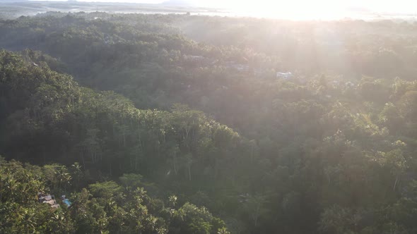 Sunrise over hillside with long sun rays pass through valley in village Bali, Indonesia