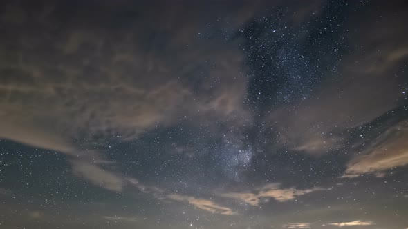 Starry Night Sky with Clouds and Stars of Milky Way Galaxy in Summer