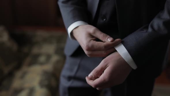 Handsome Groom Fixes His Cuffs on a Jacket. Wedding Morning. Businessman