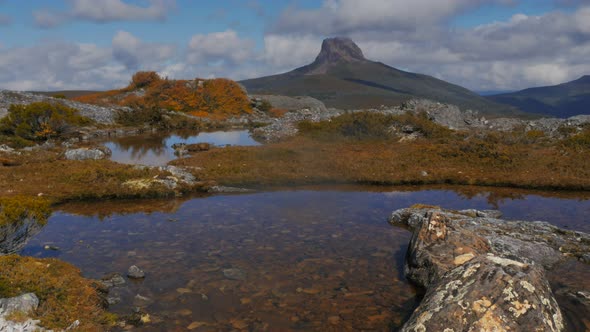 zoom in on a mountain tarn and barn bluff in cradle mountain