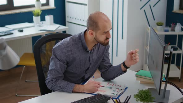 Company Employee Taking Notes on Marketing Documents