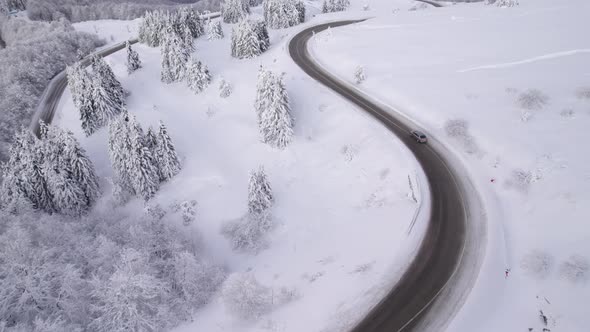 Drone Chasing SUV on Curvy Winter Road Traveling for Christmas Holidays