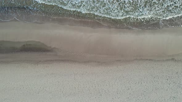 Top view beach with bright sand at sunrise.