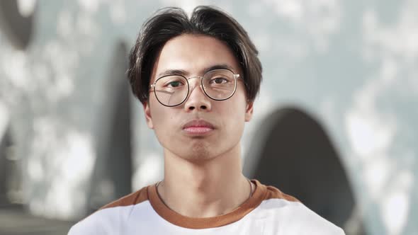 Portrait of Calm Young Asian Teenager Guy Wearing Glasses and Looking Serious Confident at Camera