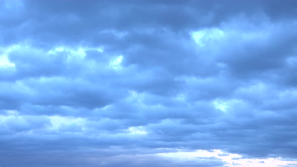 clouds with bright silhouettes in fast motion during sunset alt