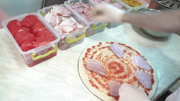 Skillful chef preparing a pizza. Hands of man in action