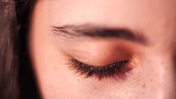 Close up on brunette female opening brown eye