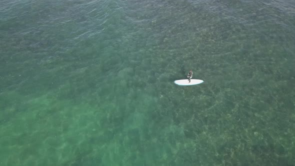 Ocean aerial: Stand up paddleboard in shallow water on sunny day