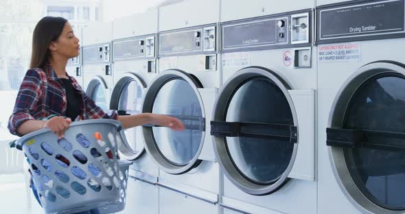 Woman putting clothes into washing machine 4k