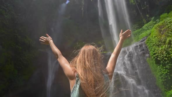 Young Woman Tourist Visits the Biggest Waterfall on the Bali Island - the Sekumpul Waterfall