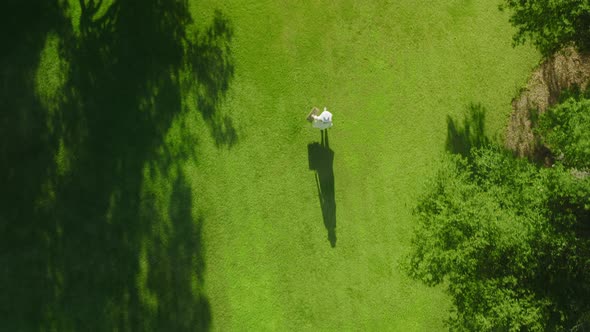 Overhead Aerial of Female Shadow Silhouette in Park on Grass at Sunset RED Shot