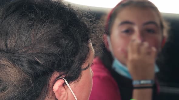 Two Young Girls Discussing in the Car at Covid Drivethru Before Swab Test