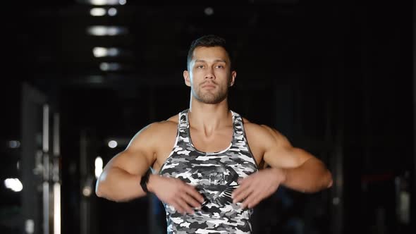 Muscular Man Trains His Hands and Shoulders with Circle Exercises