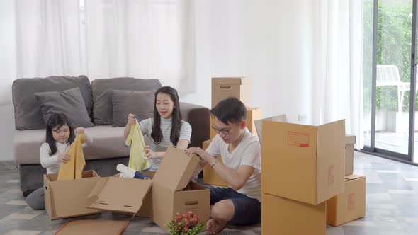 happy Asian family moving to new house with cardboard boxes and arrange the house.