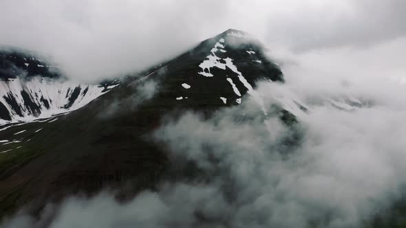 Aerial View of Nordic Landscape Flyover Beautiful Snowy Black Mountains Covered with Rolling Rainy