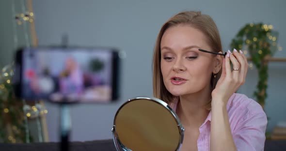 Attractive Woman Talking and Applying Mascara While Recording Video for Beauty Vlog on Smartphone