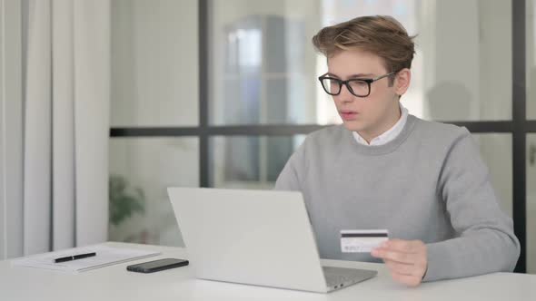 Young Man Making Online Payment Failure on Laptop in Office