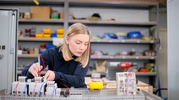 Female electrician using voltmeter and checking voltage