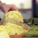 Woman's Hands Cutting a Fresh White Cabbage on Wooden Cutting Board Using Kitchen Knife - VideoHive Item for Sale
