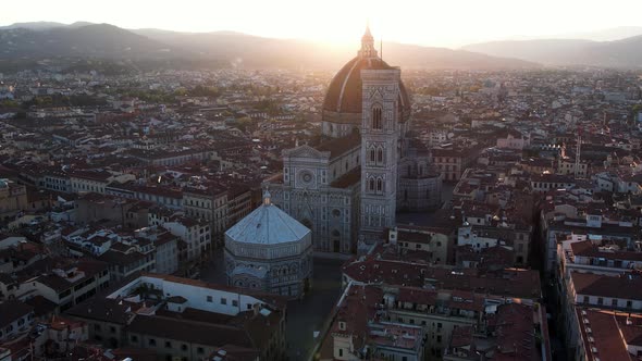 Dramatic Sunrise Sun Flare behind Florence Cathedral Church Building in Italy - Aerial