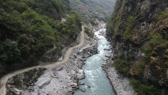 Aerial view of dirt road along the Marsyangdi River cut in the canyon