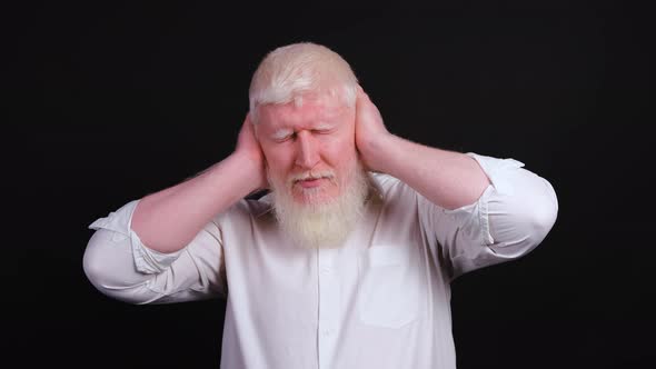 Close Up of an Albino Man Covering Ears with Hands, Nodding.