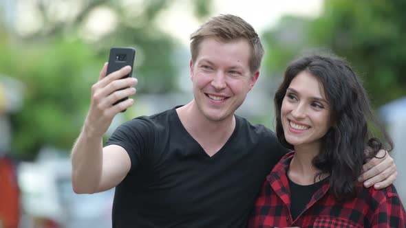 Young Couple Taking Selfie Together Outdoors