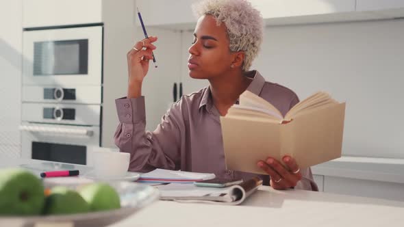 Serious Focused African American Woman Reading Textbook Hold Pencil Take Notes