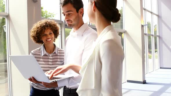 Business executives discussing over laptop