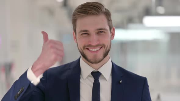 Young Businessman Showing Thumbs Up Sign