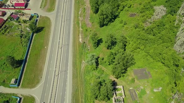 Aerial: Flying Over the Highway in Mountain Conditions. Also View of Small Tourist Town.