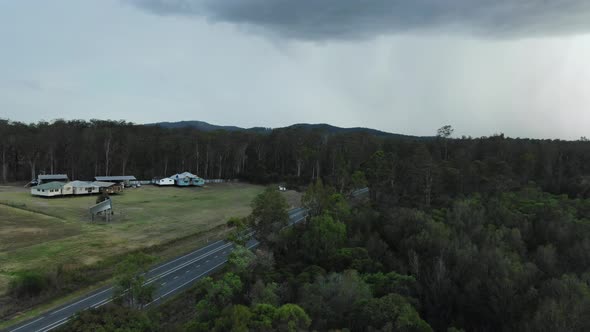 Stormy weather over traditional country style Australian bungalows and cars and trucks traffic in Qu