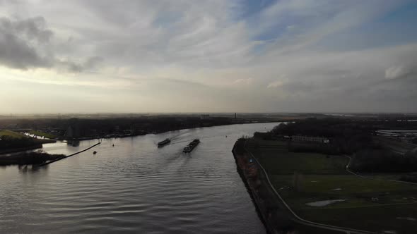 Freight Ship With Cargo Sailing At Oude Maas At Dusk Near Zwijndrecht, Netherlands. - aerial