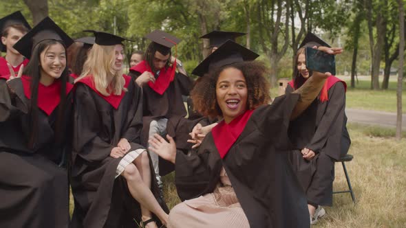 Portrait of Carefree Students in Graduation Gowns Making Selfie at Graduation Day