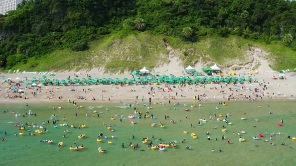 People enjoying bathing in the clear blue sea on a tube. Jeju Island, Korea.