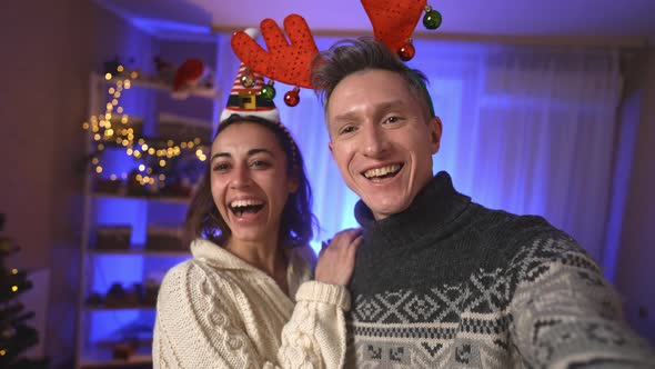 POV First Person View Lovely Couple Wearing in Festive Christmas Headbands Making Video Selfie and