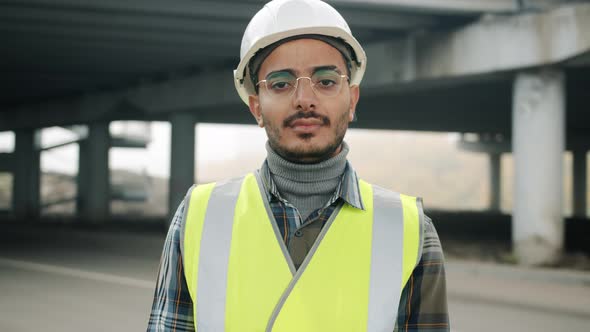 Slow Motion Portrait of Young Arab Man in Uniform Standing in Industrial Zone