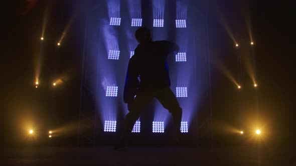 Silhouette of a Talented Young Hip Hop Dancer. Hip Hop Street Dance on a Stage in Dark Studio with