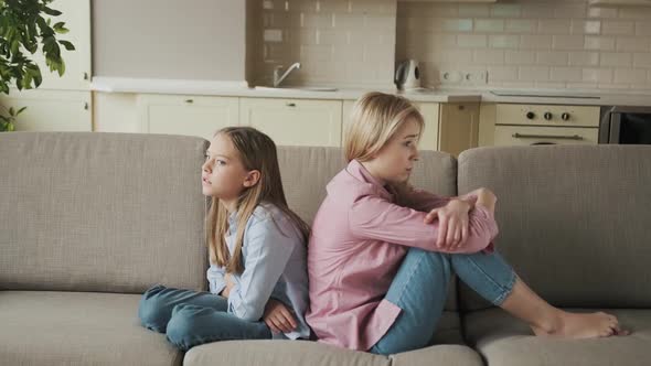 Angry Mother and Little Child Girl Sitting Back to Back on Sofa Not Talking After Fight Stubborn Kid