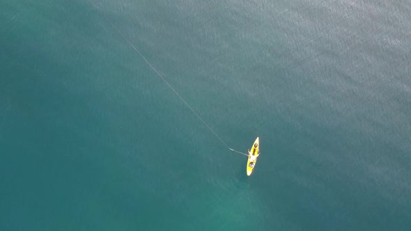 Fisherman trolling in kayak at mediterranean sea aerial drone view in middle of ocean.