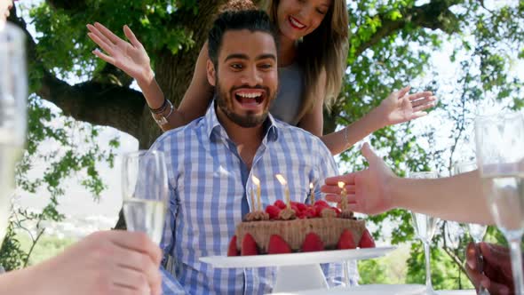 Friends celebrating mans birthday at outdoor restaurant