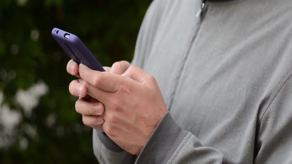 Young man typing sms on the phone