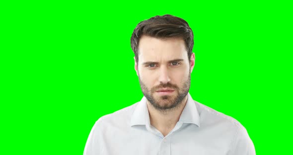 Worried man standing against green screen