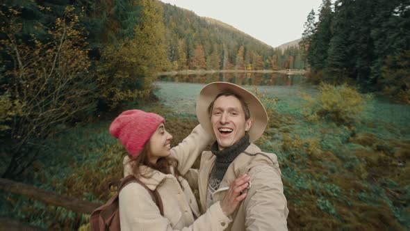 Hikers Hipstres Man and Woman on Beautiful Landscape Background with Woods and Mountain Lake Sinevir