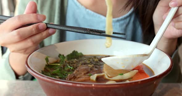 Woman having noodles in restaurant