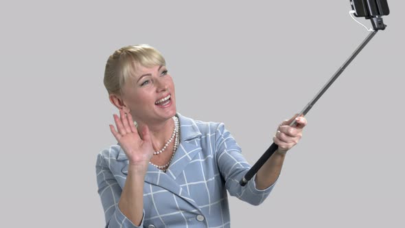 Woman Holding Monopod and Waving with Hand