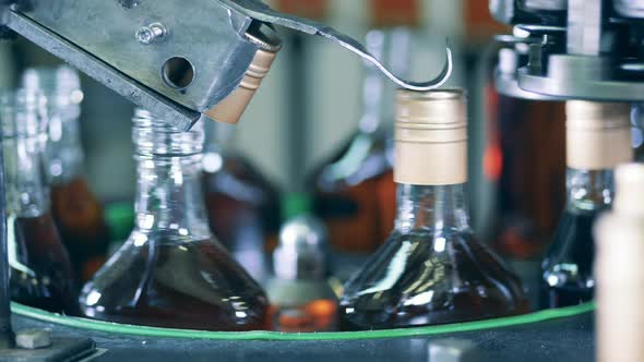 Industrial Machine Is Closing Bottles with Alcohol